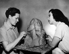 two women are working on a statue