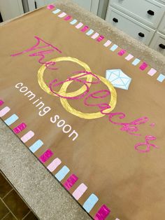 a brown paper bag with pink and blue writing on it sitting on a kitchen counter