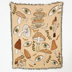 an embroidered wall hanging with mushrooms and eyeballs on it