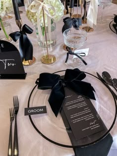 the table is set with black and white place cards, silverware, and napkins