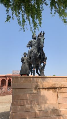 a statue of a man riding on the back of a horse next to a wall