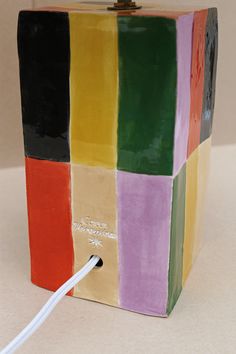 a multicolored ceramic box is plugged into a charger