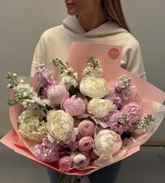 a woman holding a bouquet of flowers in her hands