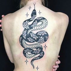 a woman's back with a tattoo on her body and a snake on it