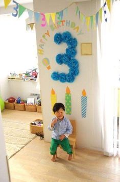 a young boy standing in front of a birthday sign