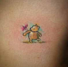 a small teddy bear tattoo on the chest