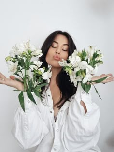 a woman is holding flowers in her hands