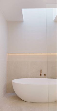 a large white bath tub sitting under a skylight