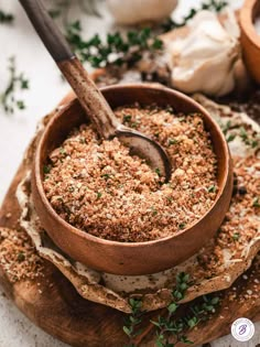 a wooden bowl filled with food sitting on top of a cutting board next to garlic