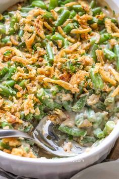 a casserole dish with green beans and bread crumbs on the side