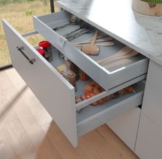 an open drawer with utensils in it