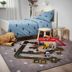 a child's bedroom with toys on the floor and in front of the bed