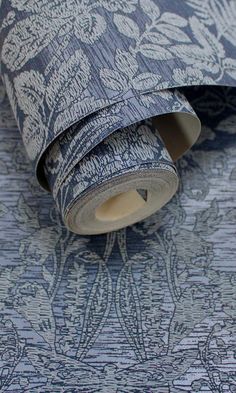 a roll of blue and white wallpaper with an intricate design on the bottom half