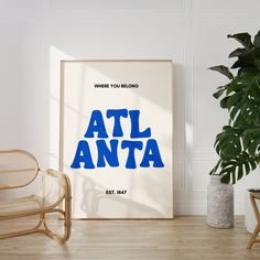 a poster with the words atl anta on it next to a chair and potted plant