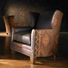 a brown leather chair sitting on top of a hard wood floor next to a wall