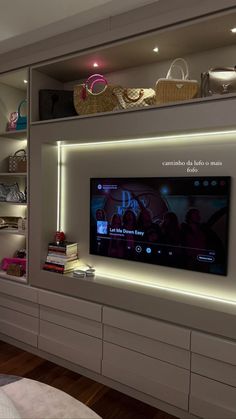 a flat screen tv sitting on top of a white entertainment center in a living room