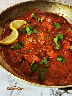 a pan filled with meat covered in sauce and garnished with cilantro