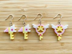 four different types of beaded earrings on a wooden surface