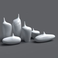 several white vases are arranged on a gray background