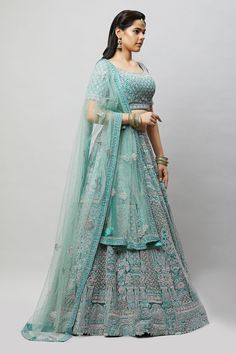 A beautiful sea green lehenga with tonal and silver stonework! Fabric: Net with satin lining All preorders will be handled by a Nazranaa Bridal Consultant who will virtually discuss measurements and minor changes according to the client's specifications Occasion: Wedding Reception WASH CARE INSTRUCTIONS - Please Dry clean only when it is applicable. Slight color variation is possible due to digital photography. Jewelry not included Turquoise Sharara For Wedding, Designer Turquoise Lehenga With Dupatta, Turquoise Lehenga With Zari Work For Eid, Semi-stitched Turquoise Lehenga For Eid, Turquoise Bollywood Lehenga For Eid, Bollywood Style Turquoise Lehenga For Eid, Designer Turquoise Embroidered Lehenga, Designer Embroidered Turquoise Lehenga, Bollywood Style Turquoise Sharara For Wedding