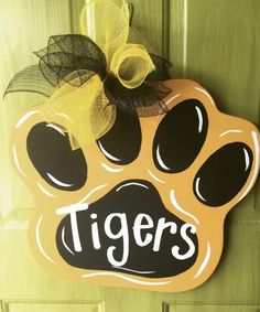 a door hanger with a dog's paw and the word tigers painted on it