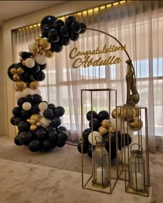 black and white balloons are hanging from the ceiling in front of a sign that reads congratulations cecilia