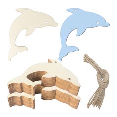 dolphin cutouts and string on white background with blue one in the middle, two dolphins jumping out of water