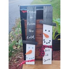 two snowmen made out of pallets sitting on top of a wooden box with the words come in from the cold and let it grow