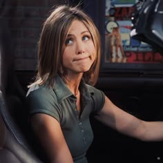 a woman sitting in the driver's seat of a car