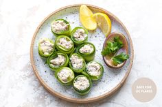 stuffed green peppers on a plate with lemon wedges and garnishes to the side