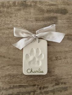 a ceramic ornament with a dog's paw and name on the front