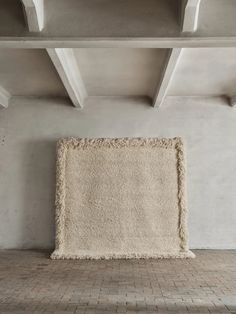 a white rug on the floor in an empty room