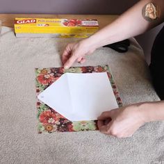 someone is cutting out a piece of paper on top of a table with scissors and glue