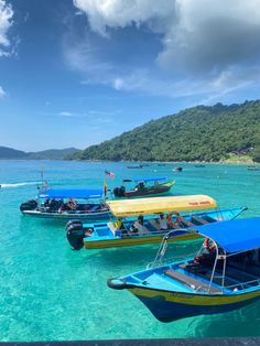 several boats in the water with people on them