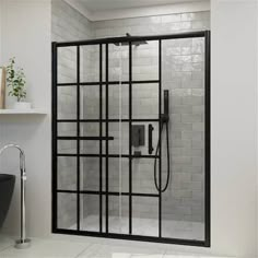 a bathroom with a glass shower door and white tiled walls, along with a black sink