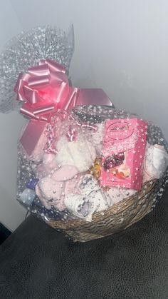 a basket filled with lots of baby items on top of a chair next to a wall