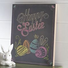 a chalkboard sign that says happy easter next to a white bunny on a green shelf