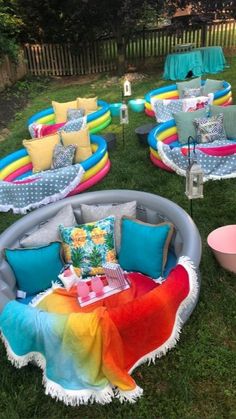 an inflatable pool with lots of pillows and blankets on it, surrounded by lawn furniture