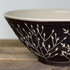 a black and white bowl sitting on top of a wooden table