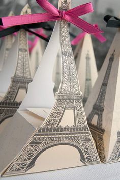 the eiffel tower is made out of paper and tied with a pink ribbon