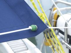 a blue sail boat with white and yellow ropes on it's side, close up