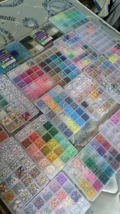 many different colors of beads are on the table and there is no image to describe