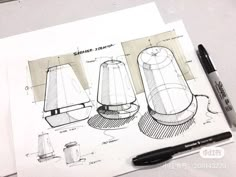 sketches of lamps are shown on top of a piece of paper with a pen next to it