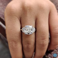 a woman's hand with a diamond ring on top of her finger and an engagement band