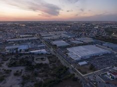 an aerial view of a large industrial area in the middle of a city at sunset