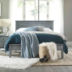 a bedroom scene with focus on the bed and rugs in front of the window