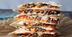 three quesadillas stacked on top of each other with meat and cheese in them