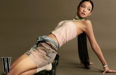 a woman with long hair sitting on top of a chair next to a pair of boots