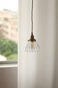 a light hanging from a ceiling in front of a window