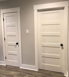 an empty room with three white doors in it